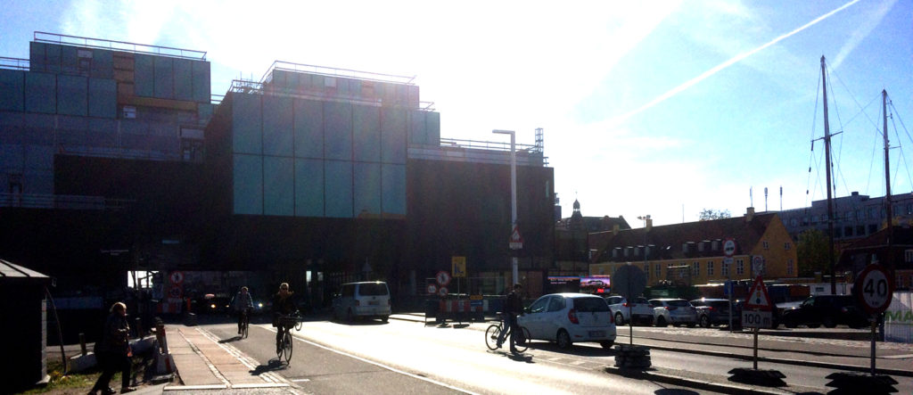 A new building is under construction close to older houses.